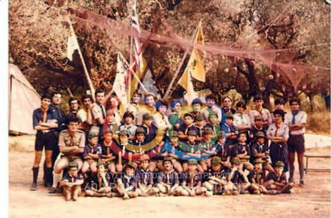 1980, 24η Κατασκήνωση Αγέλης του 2ου Συστήματος  Προσκόπων Πάτρας στις Καμάρες, μαζί με τις Αγέλες του 5ου και του 10ου Συστήματος Πάτρας. Οικογενειακή φωτογραφία στον ιστό της κατασκήνωσης.